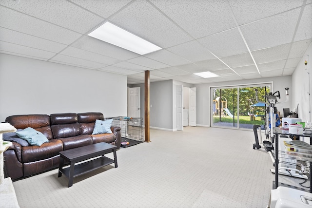 living room featuring carpet floors, a drop ceiling, and baseboards