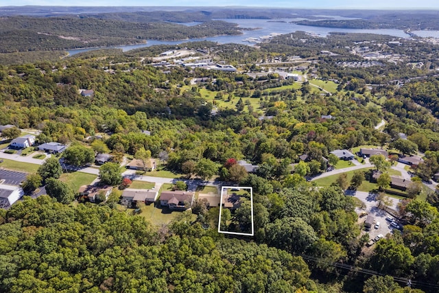 birds eye view of property with a water view and a wooded view