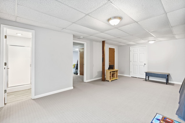 interior space with carpet, a paneled ceiling, and baseboards