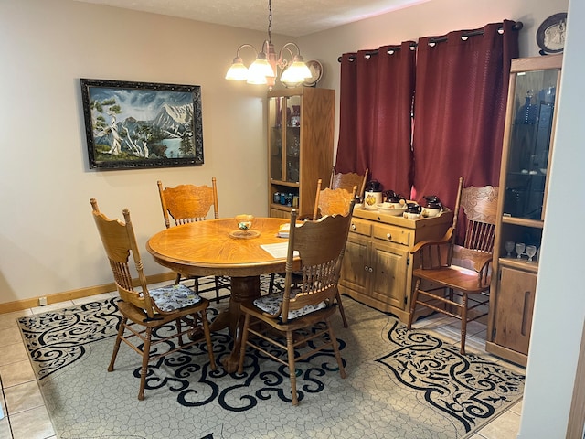 dining room with an inviting chandelier, light tile patterned floors, and a textured ceiling