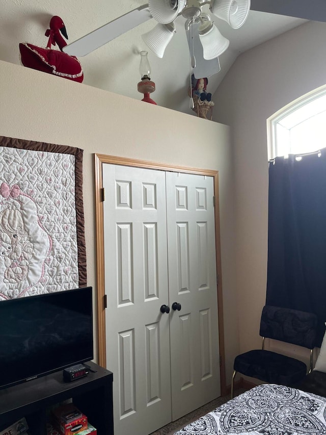 bedroom with a closet, vaulted ceiling, and ceiling fan