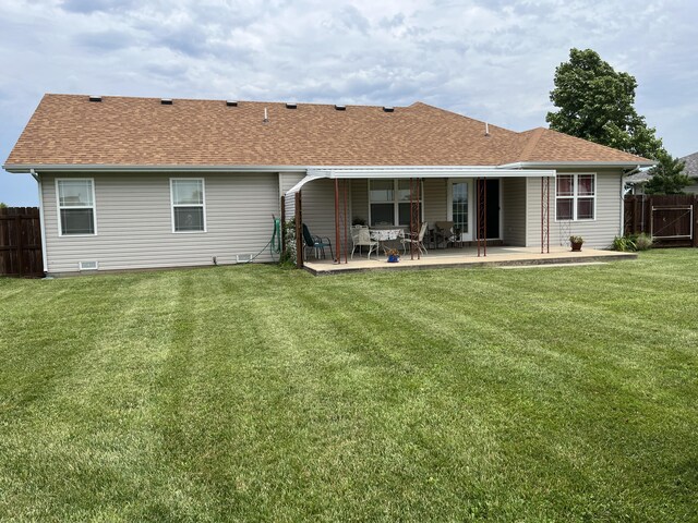 1316 E 476th Rd, Bolivar, MO 65613 - back of house featuring a patio area, a lawn, a shingled roof, and fence