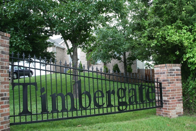 view of gate with a lawn