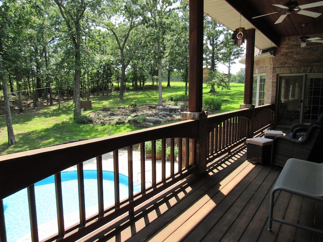 wooden terrace with ceiling fan and a lawn