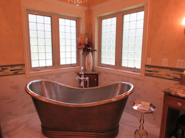 interior space with ornamental molding, a healthy amount of sunlight, stone counters, and tile walls