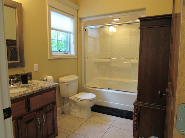 full bathroom featuring shower / bath combination with glass door, vanity, tile patterned flooring, and toilet