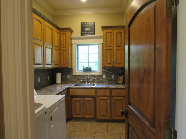 kitchen with decorative backsplash, sink, crown molding, washing machine and clothes dryer, and light tile patterned floors