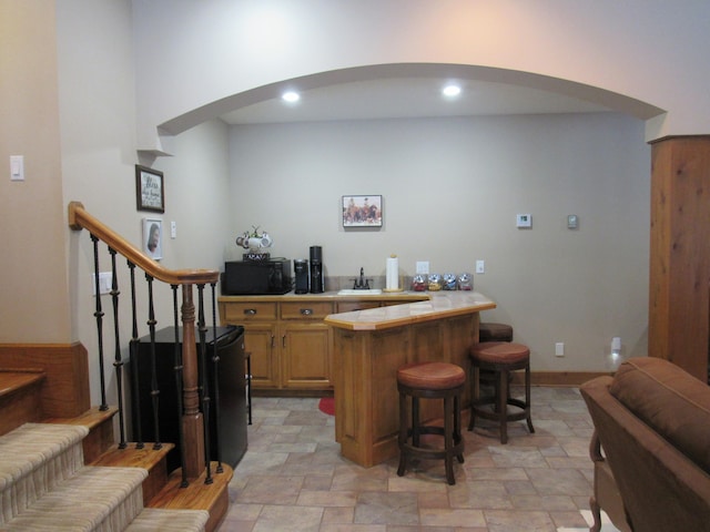 bar with sink and tile countertops