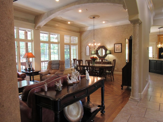 tiled living room with ornamental molding, a chandelier, and decorative columns