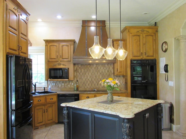 kitchen with ornate columns, crown molding, a kitchen island, black appliances, and light tile patterned floors