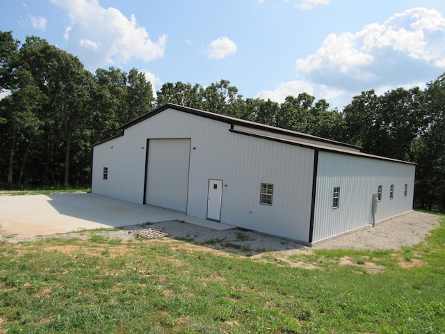 view of outbuilding featuring a garage and a lawn