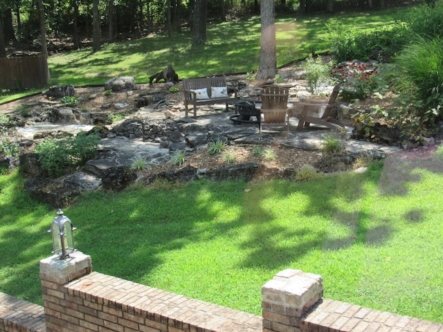 view of yard featuring a fire pit and a patio