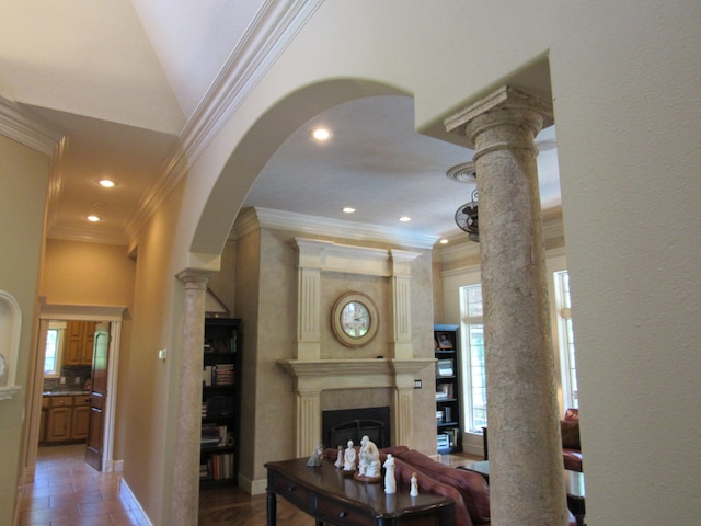 living room with a fireplace, crown molding, and ornate columns