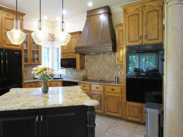 kitchen featuring black appliances, premium range hood, a center island, and light stone countertops