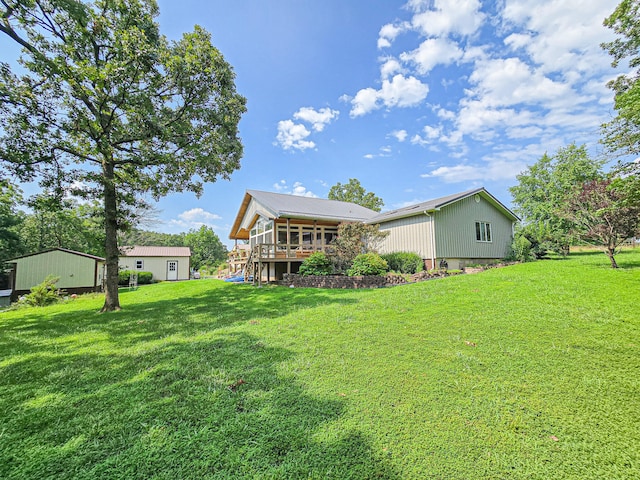 rear view of house with a yard and a wooden deck