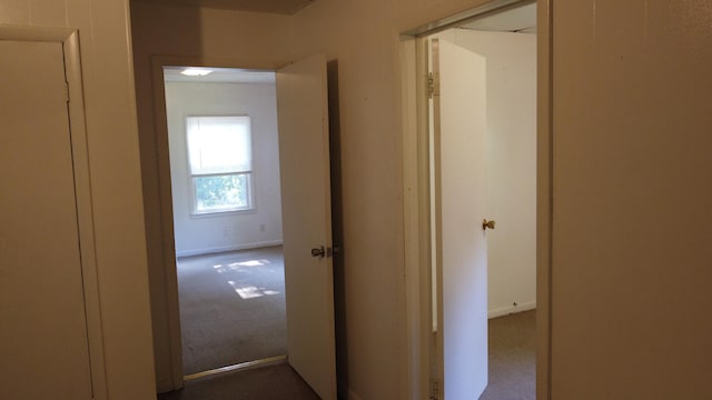 hall featuring dark colored carpet