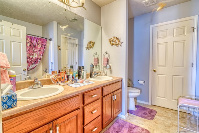 full bathroom with toilet, a sink, visible vents, and double vanity