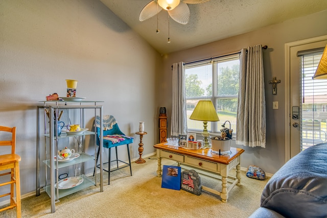 interior space with light carpet, a textured ceiling, vaulted ceiling, and ceiling fan