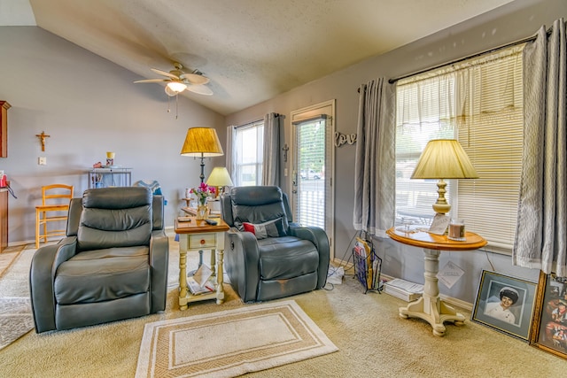 living area featuring lofted ceiling, a ceiling fan, baseboards, and carpet floors