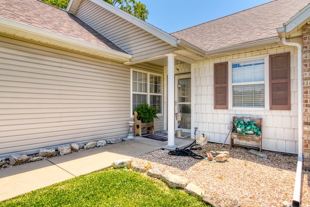 doorway to property with roof with shingles