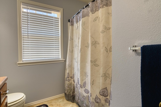 full bathroom with curtained shower, tile patterned floors, toilet, vanity, and baseboards