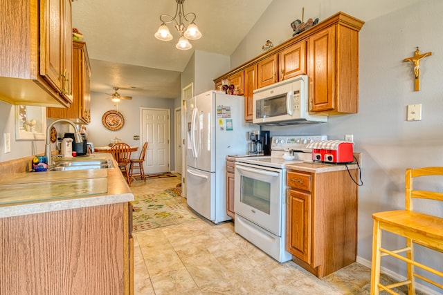 kitchen featuring white appliances, ceiling fan with notable chandelier, decorative light fixtures, sink, and vaulted ceiling