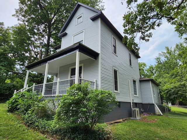 view of home's exterior featuring a lawn, ac unit, and a porch