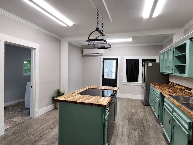 kitchen with a kitchen island, a wall unit AC, green cabinetry, and wood counters