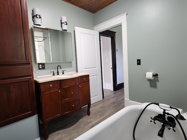 bathroom featuring a bath, wood ceiling, hardwood / wood-style floors, and vanity