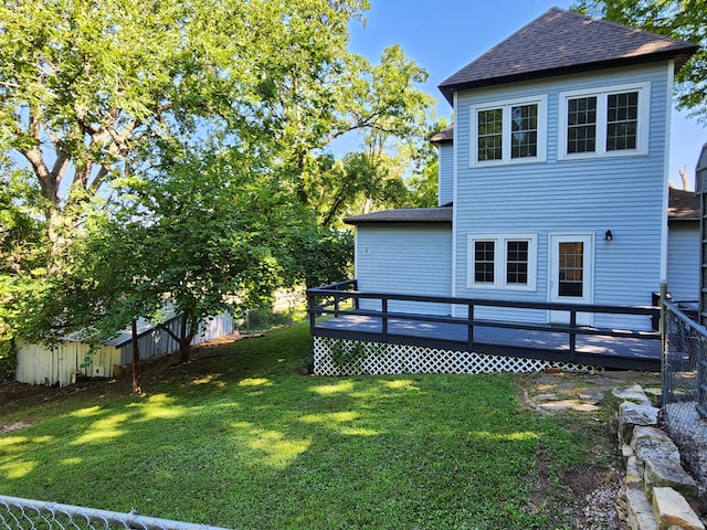 rear view of house featuring a deck and a lawn