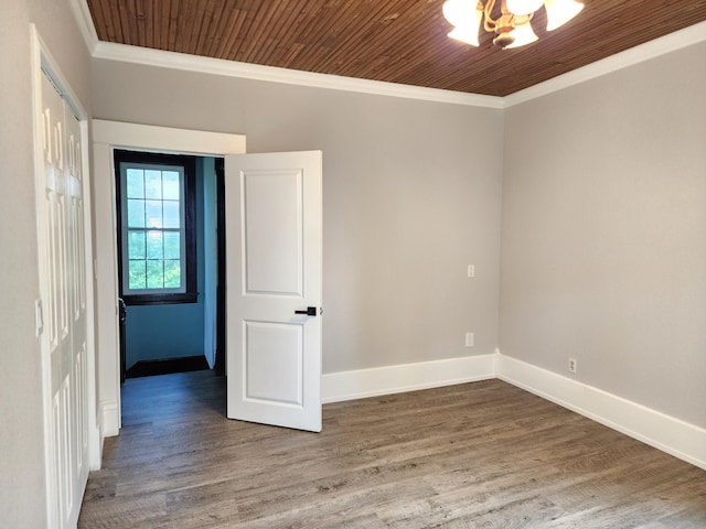 spare room with wood ceiling, crown molding, a chandelier, and hardwood / wood-style flooring