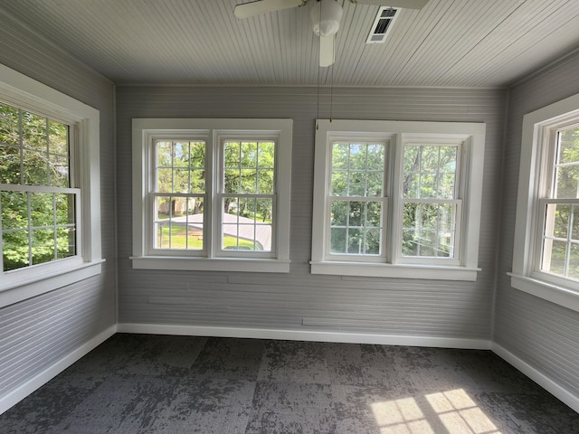 unfurnished sunroom featuring ceiling fan