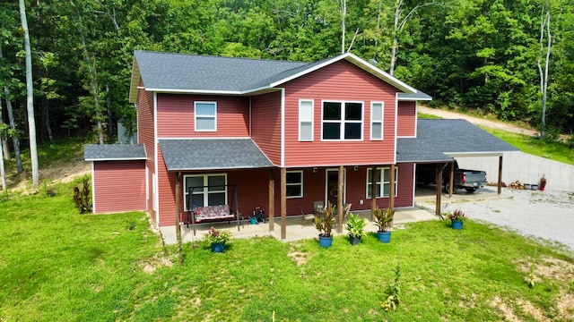 front of property with a front lawn, a porch, and a carport