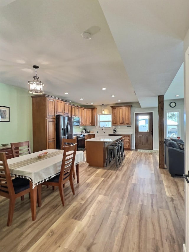 dining room featuring sink, light wood-type flooring, and a chandelier