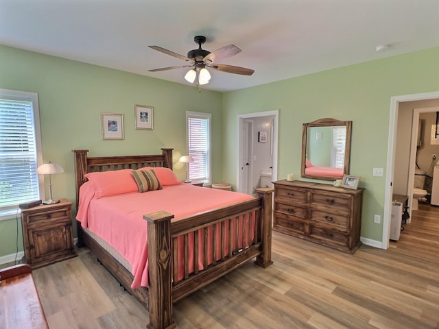 bedroom featuring ceiling fan, light wood-type flooring, and connected bathroom