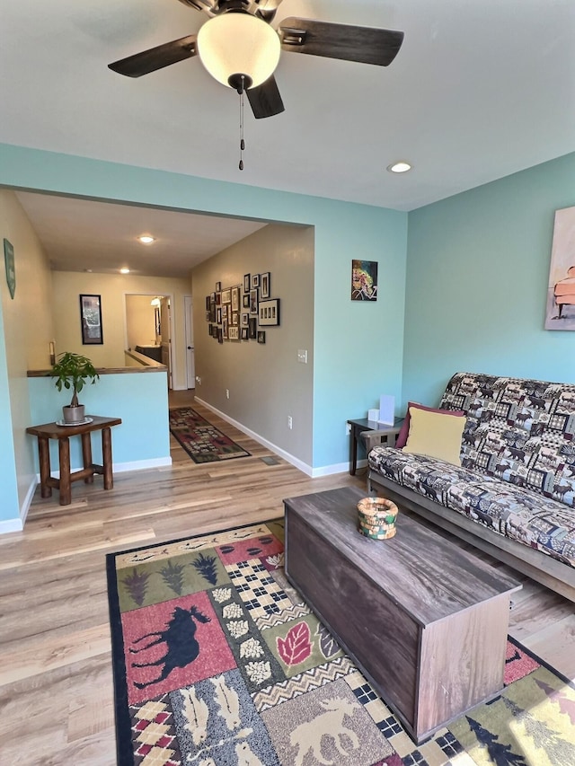 living room with ceiling fan and light hardwood / wood-style flooring