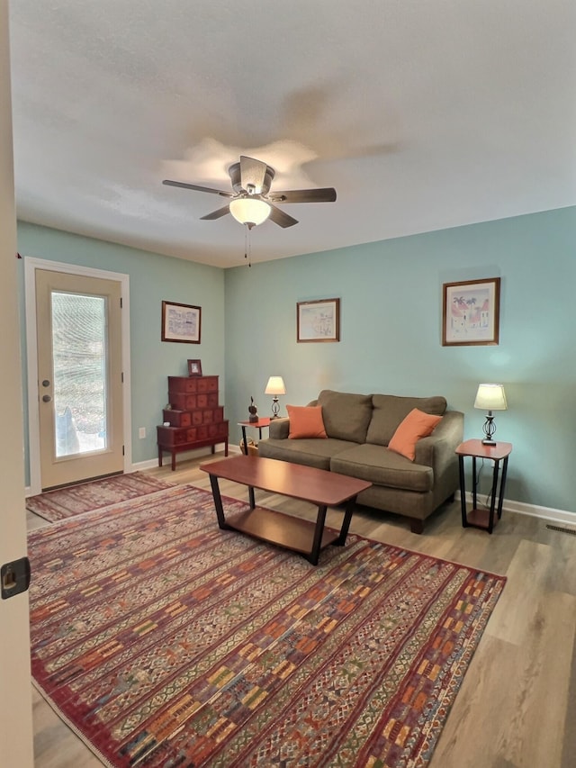 living room with light wood-type flooring and ceiling fan