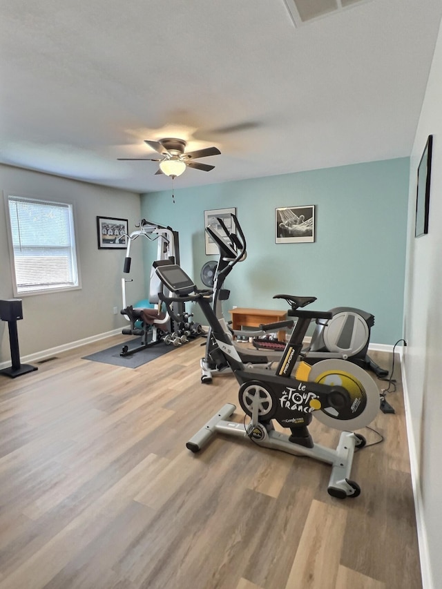 workout area featuring light wood-type flooring and ceiling fan