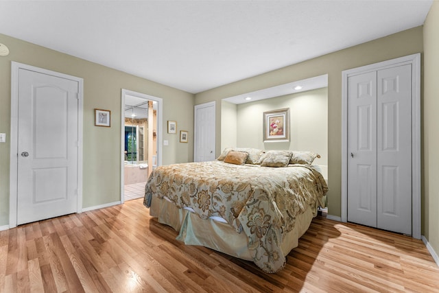 bedroom with connected bathroom and light wood-type flooring