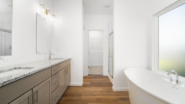 bathroom featuring wood-type flooring, independent shower and bath, and vanity