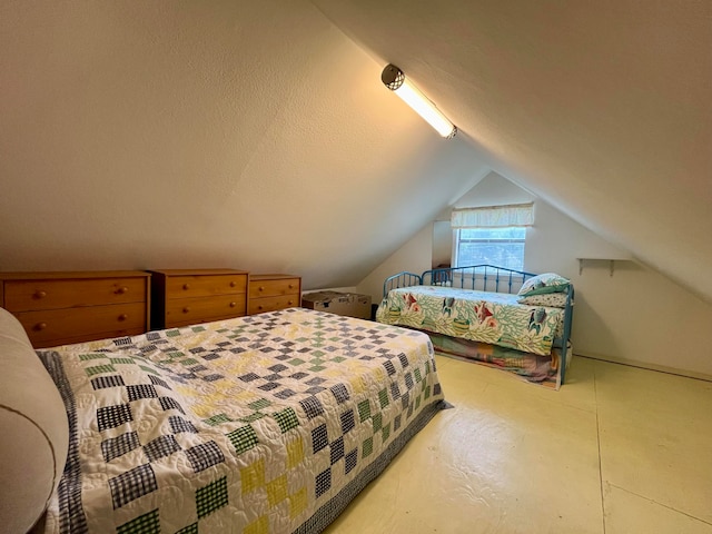 bedroom with lofted ceiling and a textured ceiling