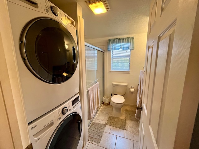 laundry area featuring light tile patterned flooring and stacked washer and dryer