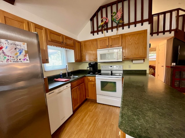 kitchen featuring high vaulted ceiling, white appliances, sink, kitchen peninsula, and light hardwood / wood-style flooring