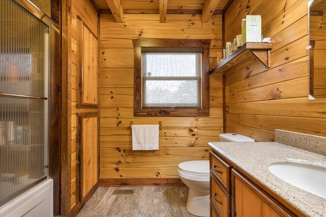 bathroom with visible vents, toilet, wooden walls, and vanity