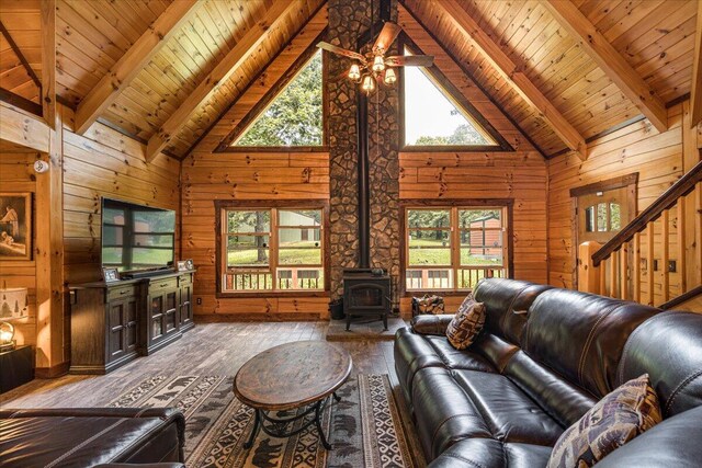 living room with hardwood / wood-style flooring, wooden walls, and beam ceiling