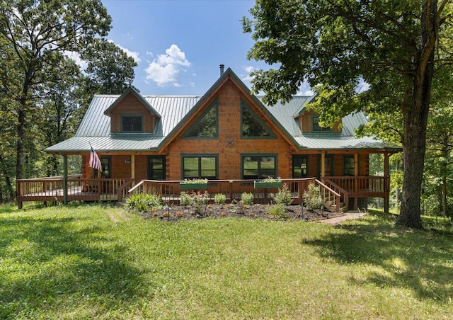 back of property featuring metal roof, a yard, and covered porch