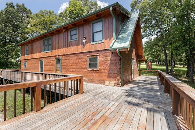 back of property featuring metal roof and a wooden deck