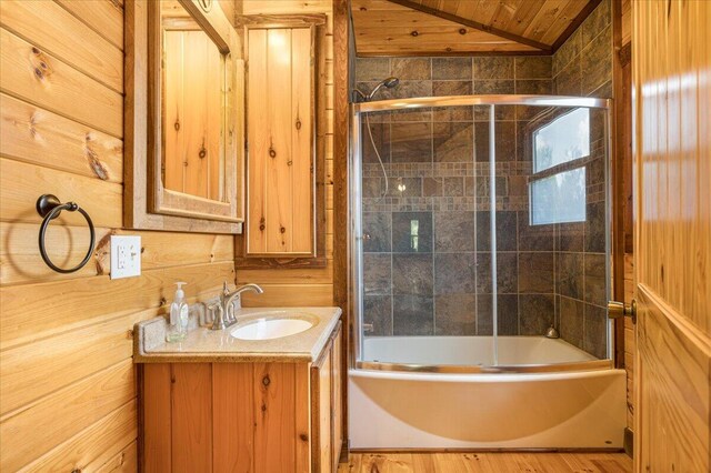 bathroom featuring bath / shower combo with glass door, wood ceiling, wood walls, vaulted ceiling, and vanity