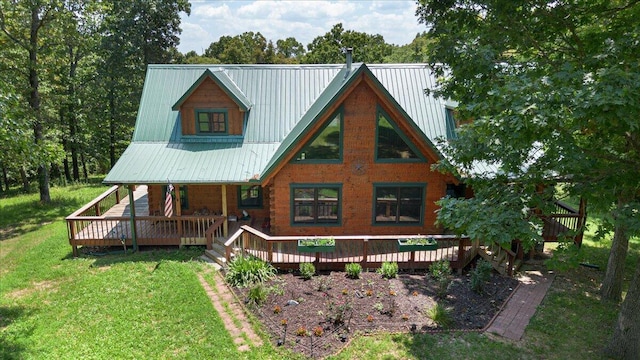 rear view of house with metal roof and a yard