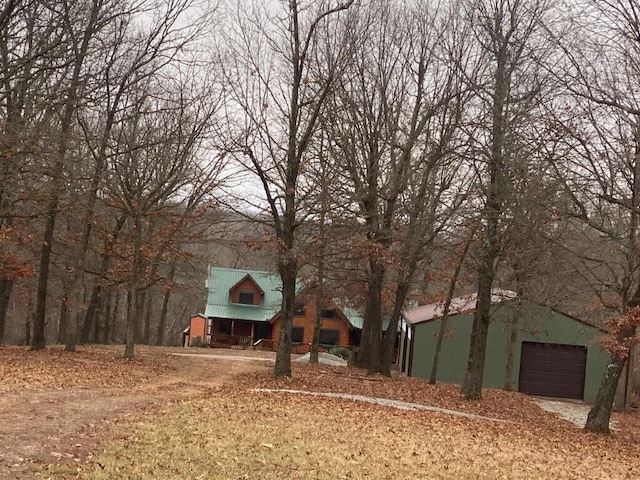 view of front of property featuring metal roof, an outdoor structure, and an attached garage